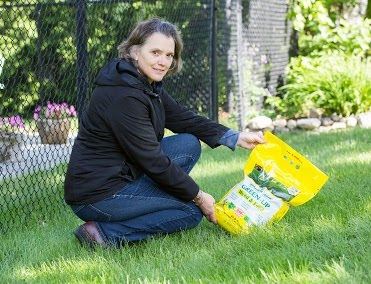Woman Holding a Bag of Lawn Fertilizer
